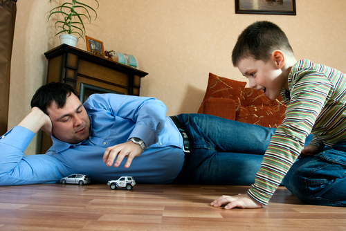 dad and boy playing with a car